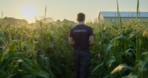 Man in #39northstl t-shirt walking in field
