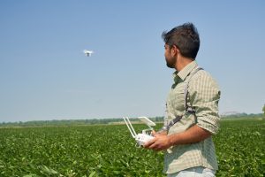 man flying drone in field